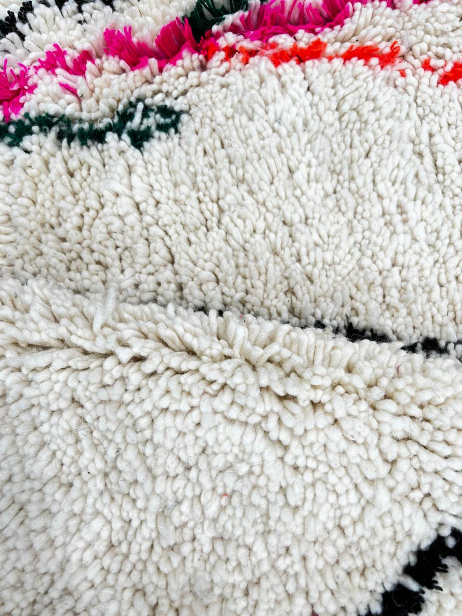 Round Moroccan wool rug with minimal Berber symbols on a white  background