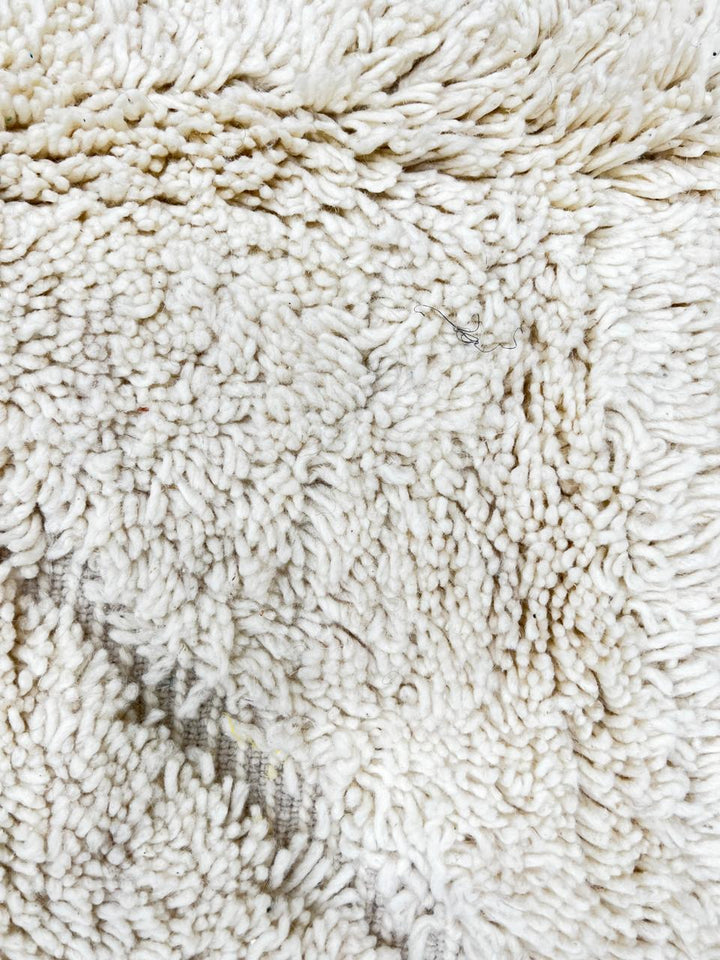 Round Moroccan wool rug with white color and hand-carved diamond lines