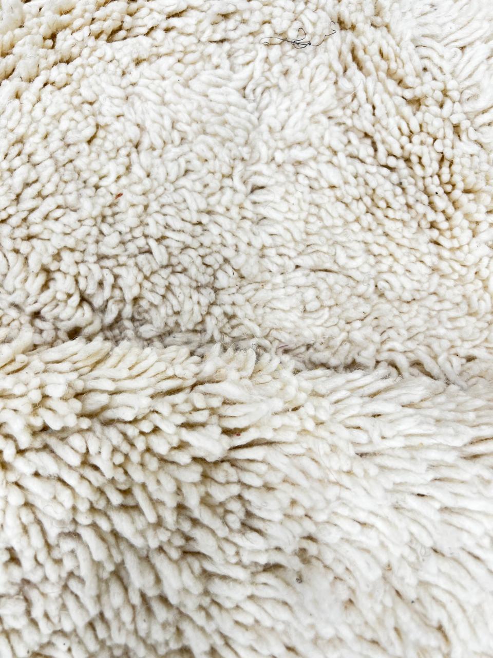 Round Moroccan wool rug with white color and hand-carved diamond lines