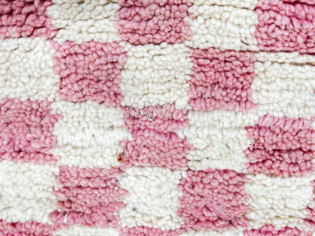 Handmade round Moroccan wool rug with pink and white checkerboard pattern, featuring a soft plush texture.