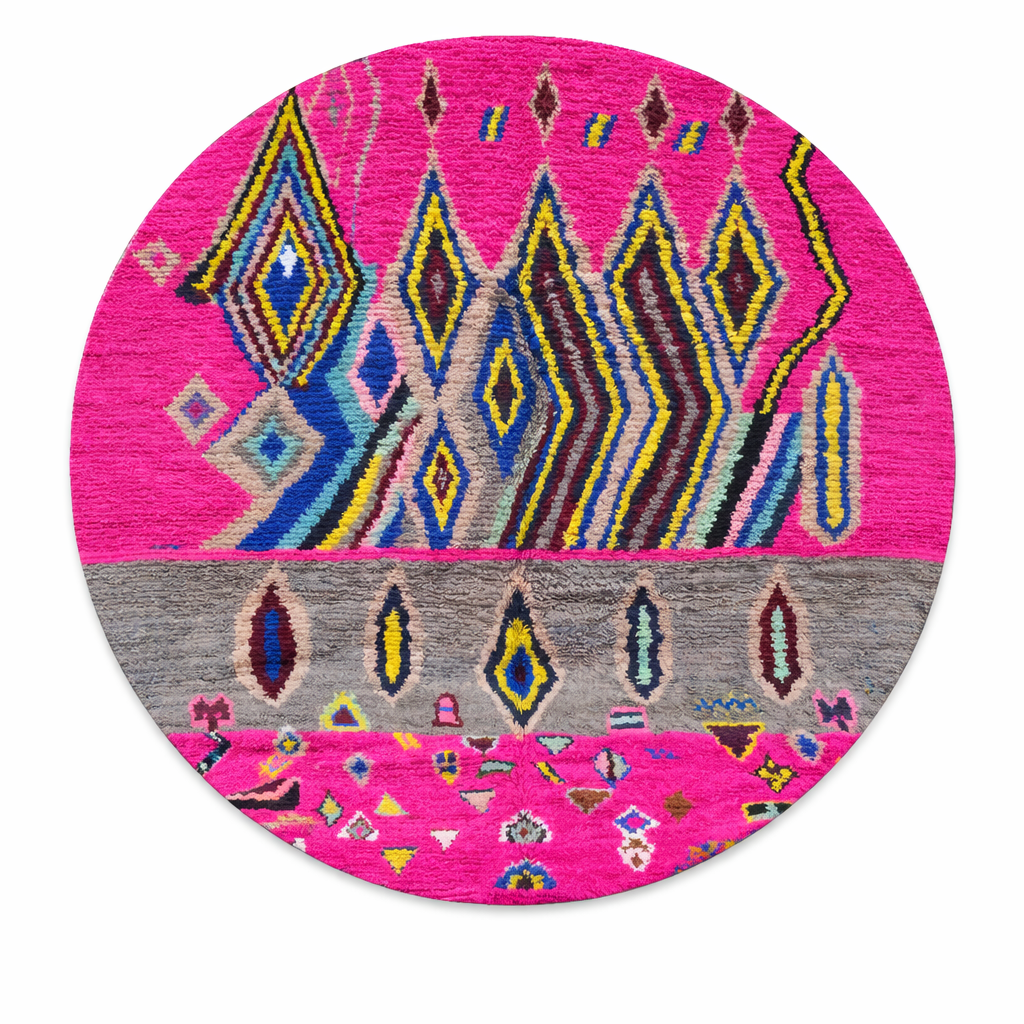 Round pink Moroccan wool rug with colorful Berber geometric patterns