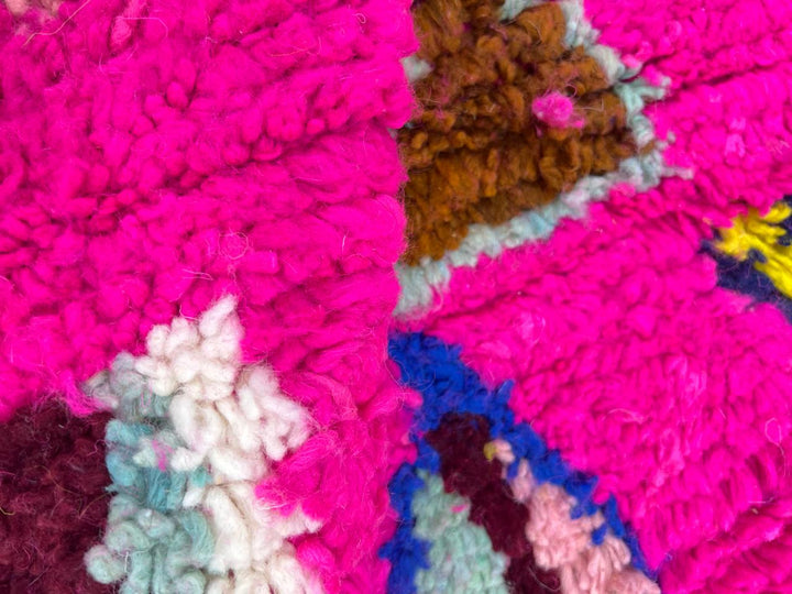 Round pink Moroccan wool rug with colorful Berber geometric patterns