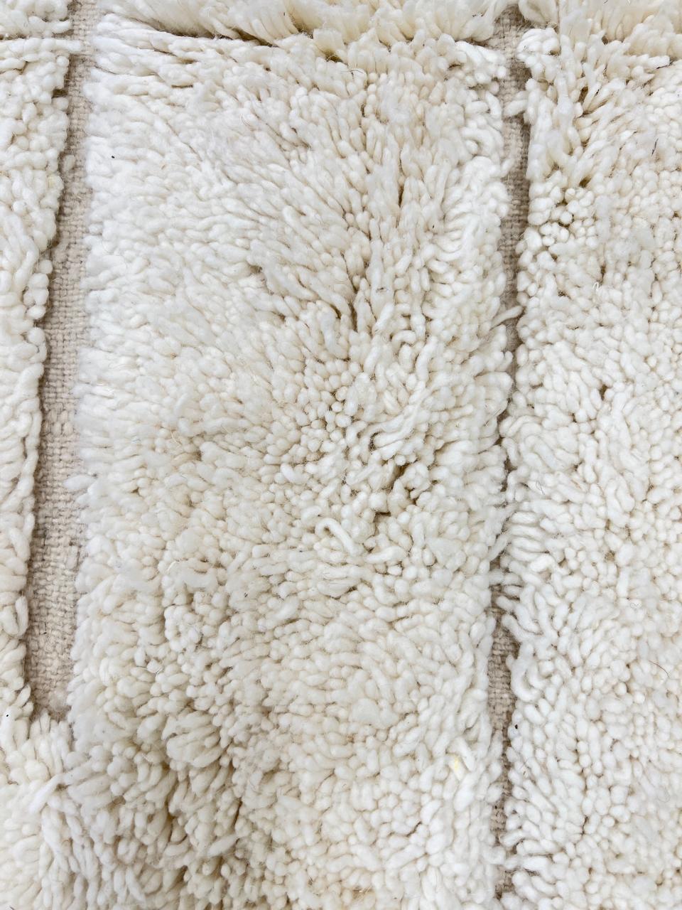 Round white Moroccan wool rug with subtle carved geometric line pattern