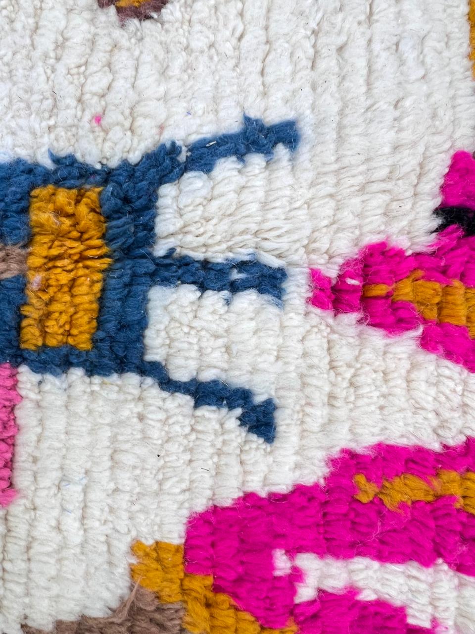 Round white Moroccan wool rug with colorful Berber symbols on white background