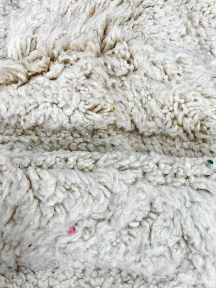 Round white Moroccan wool shag rug with minimalist solid design