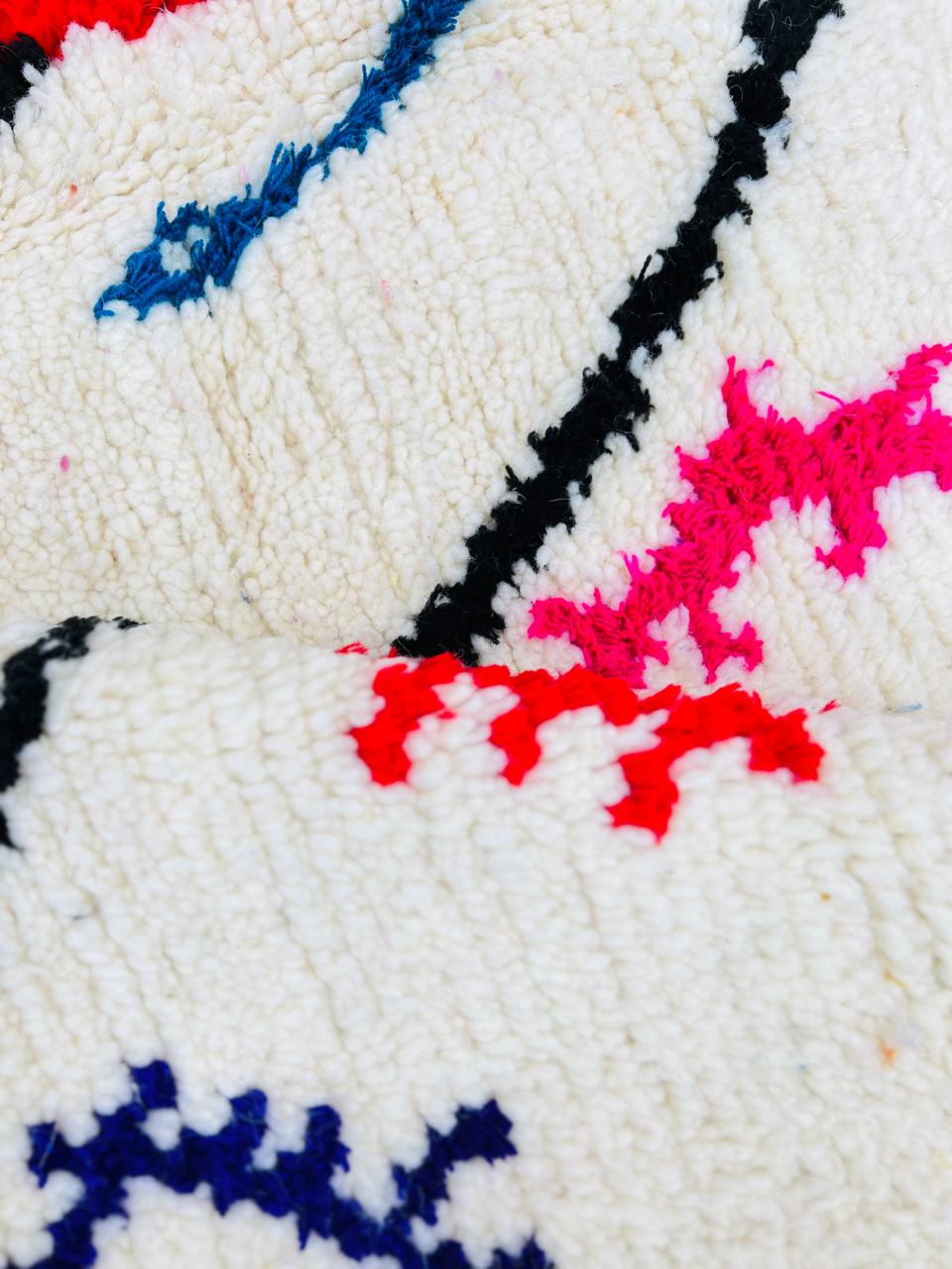 Handmade round Moroccan wool rug with colorful Berber symbols and black geometric lines