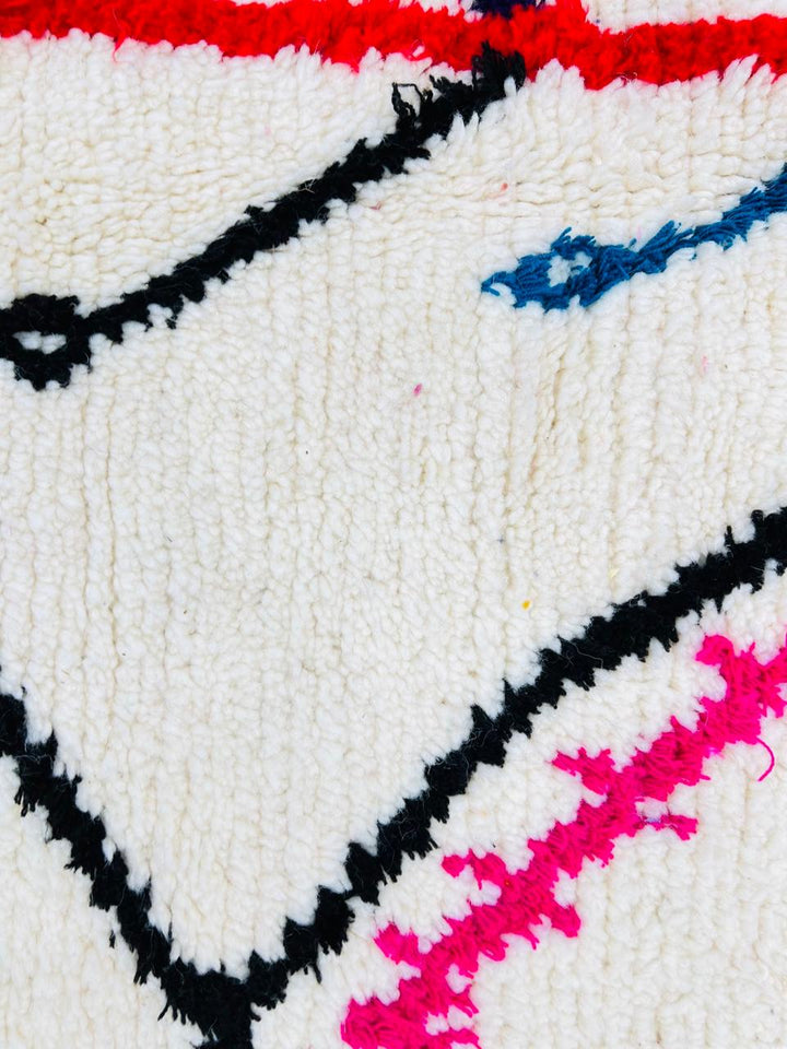 Handmade round Moroccan wool rug with colorful Berber symbols and black geometric lines