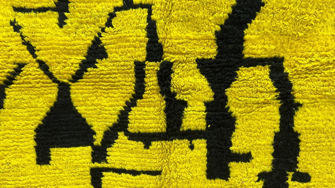Handmade round Moroccan wool rug in yellow and black abstract Berber design