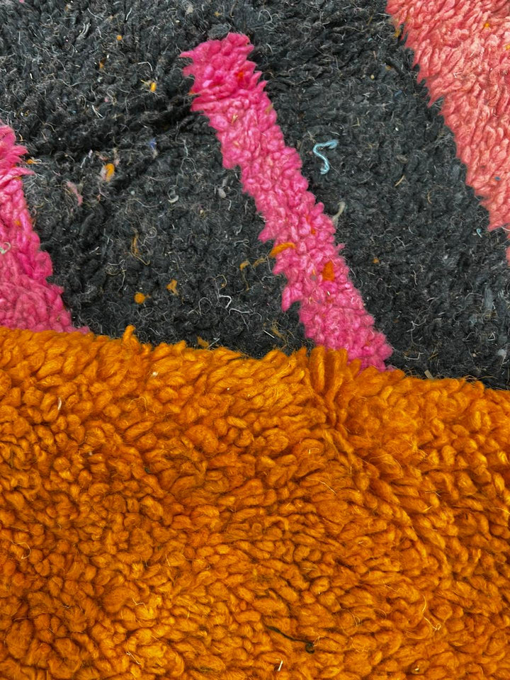 Round Moroccan Berber wool rug with abstract geometric motif, handmade by artisans.