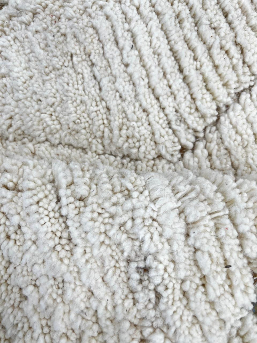 Round Moroccan wool rug with subtle carved diamond pattern, handmade by Berber artisans