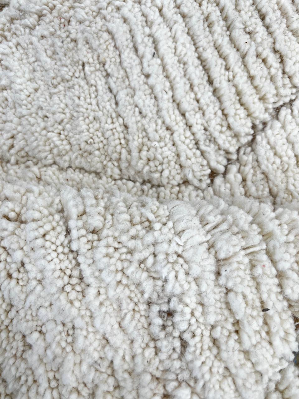 Round Moroccan wool rug with subtle carved diamond pattern, handmade by Berber artisans