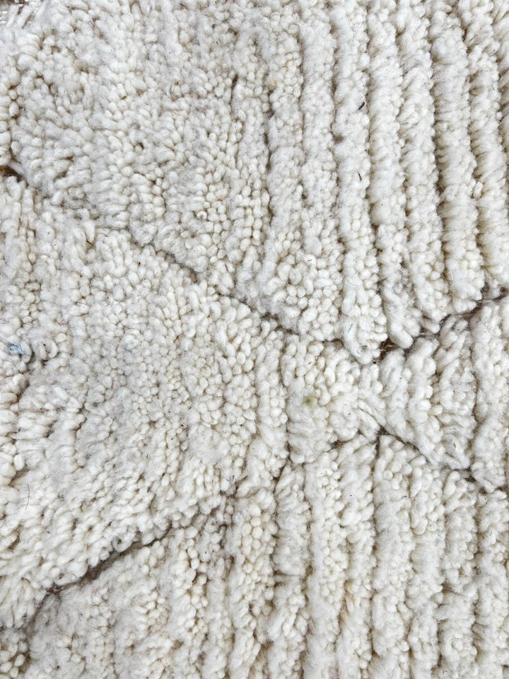 Round Moroccan wool rug with subtle carved diamond pattern, handmade by Berber artisans