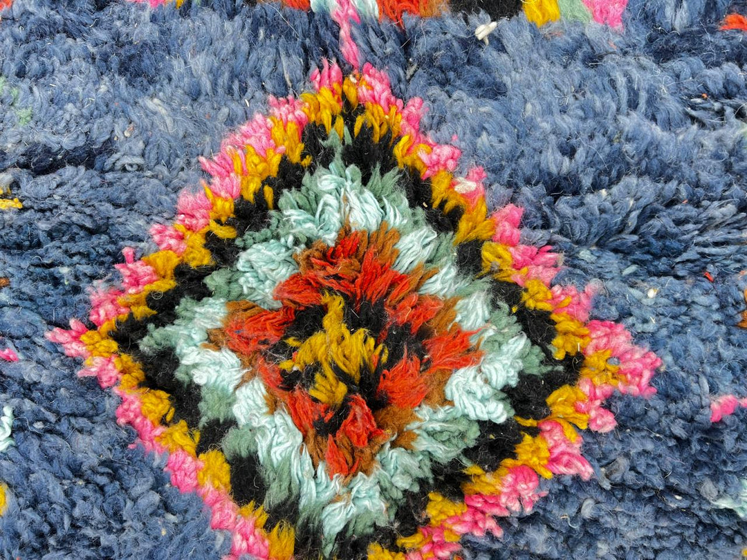 Round blue Moroccan rug with colorful Berber diamond motifs, handmade wool design