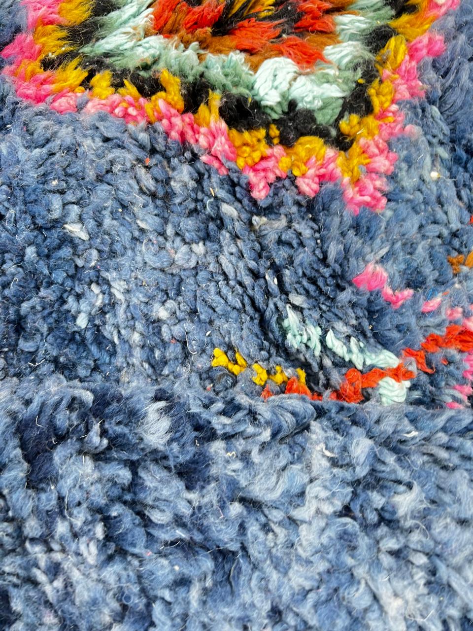 Round blue Moroccan rug with colorful Berber diamond motifs, handmade wool design