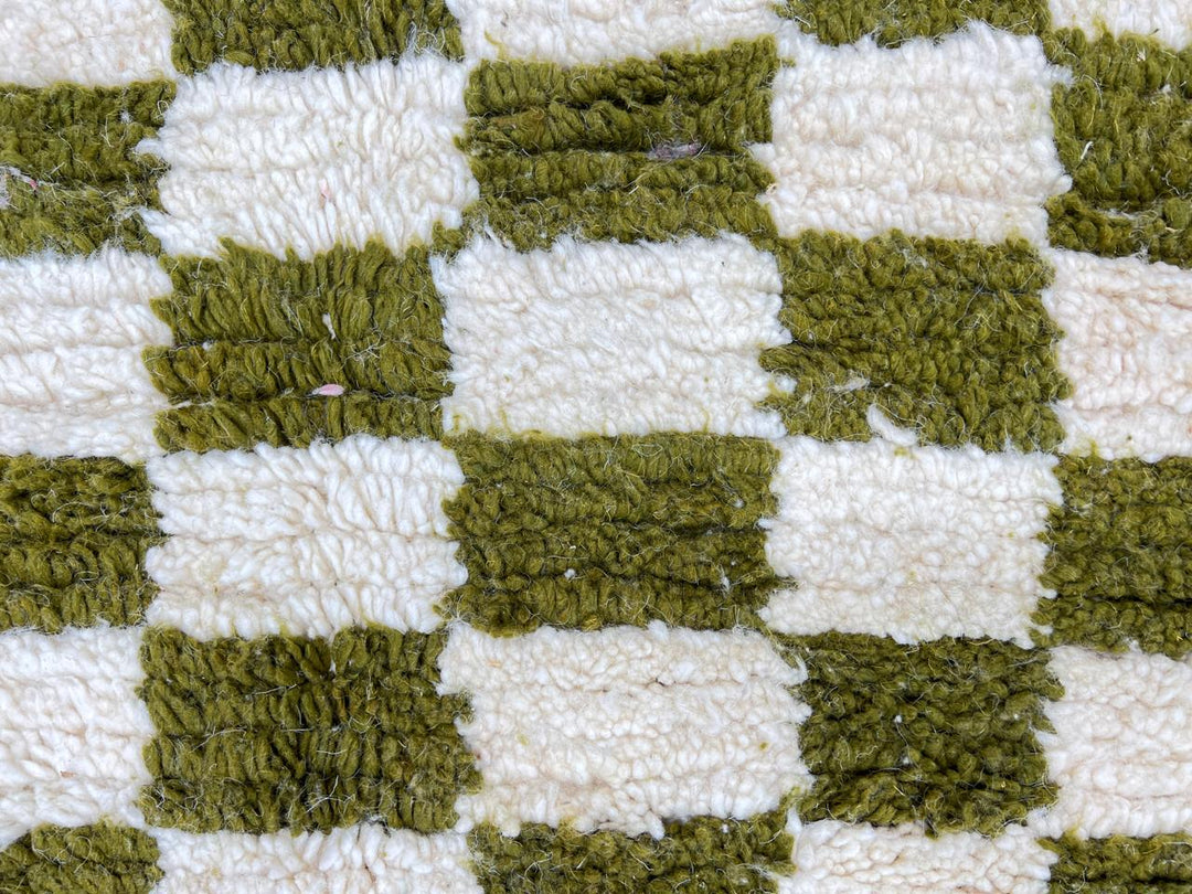 Round Moroccan rug with green and white checkerboard pattern