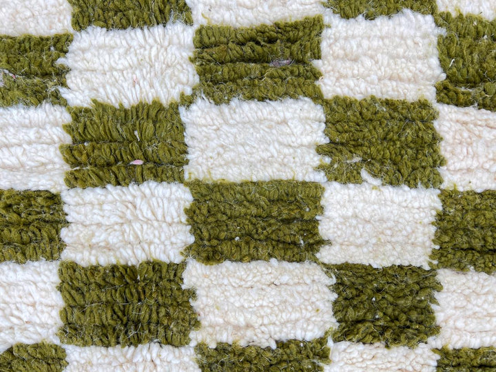 Round Moroccan rug with green and white checkerboard pattern