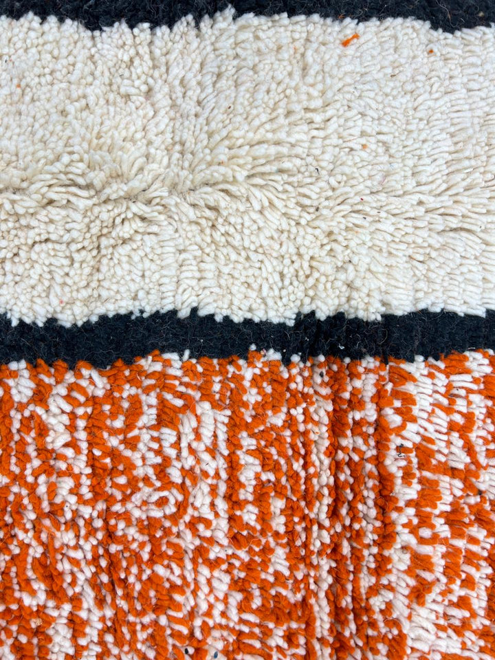 Round Moroccan rug with modern abstract geometric pattern in orange, white, black, teal, grey and rust tones, handmade wool design