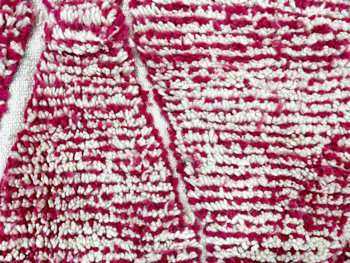 Round pink Moroccan wool rug with white Beni Ourain diamond pattern, handmade by Berber artisans