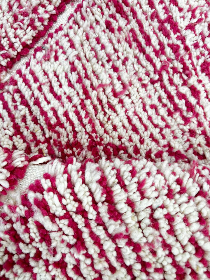 Round pink Moroccan wool rug with white Beni Ourain diamond pattern, handmade by Berber artisans