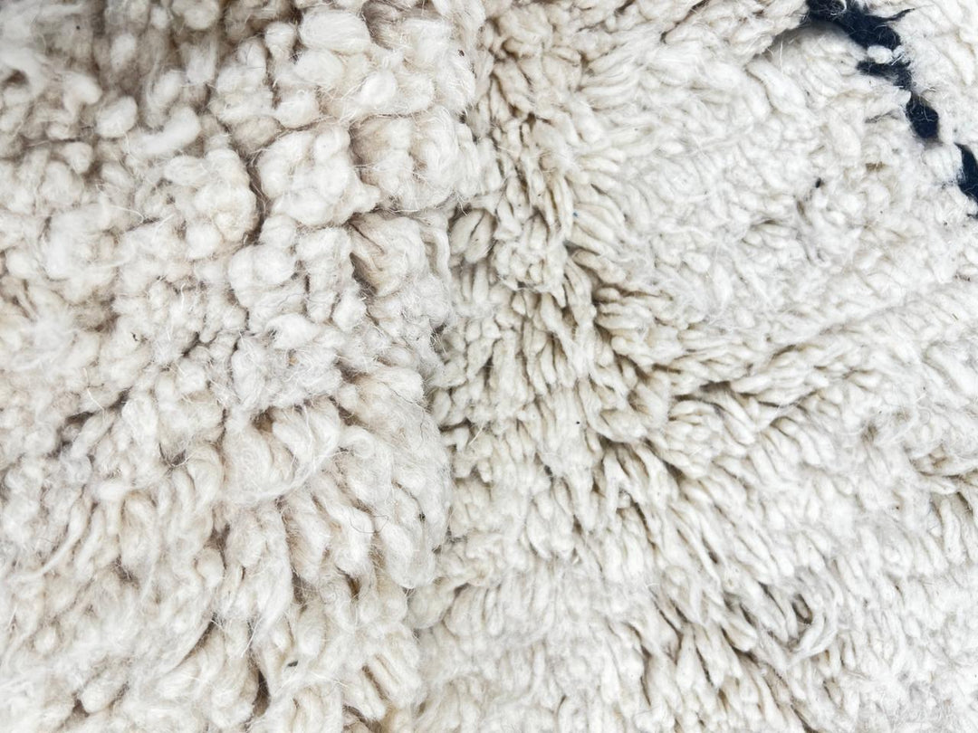 Round white Moroccan rug with black diamond line pattern, handmade wool design