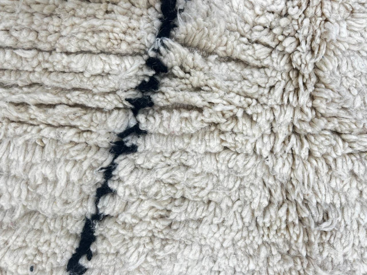 Round white Moroccan rug with black diamond line pattern, handmade wool design