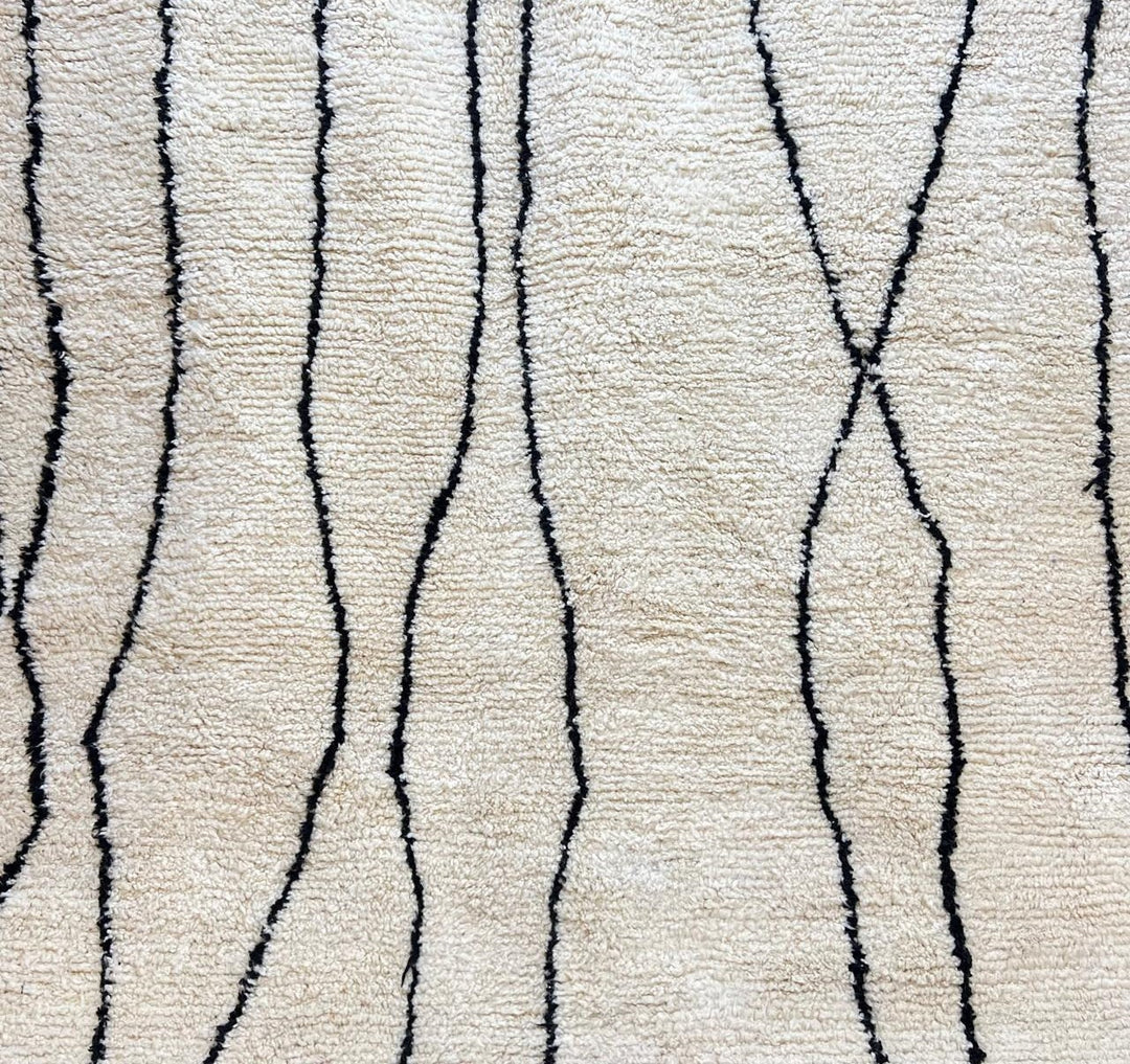 Round white Moroccan wool rug with minimalist black Berber lines, handmade artisan round rug on white background