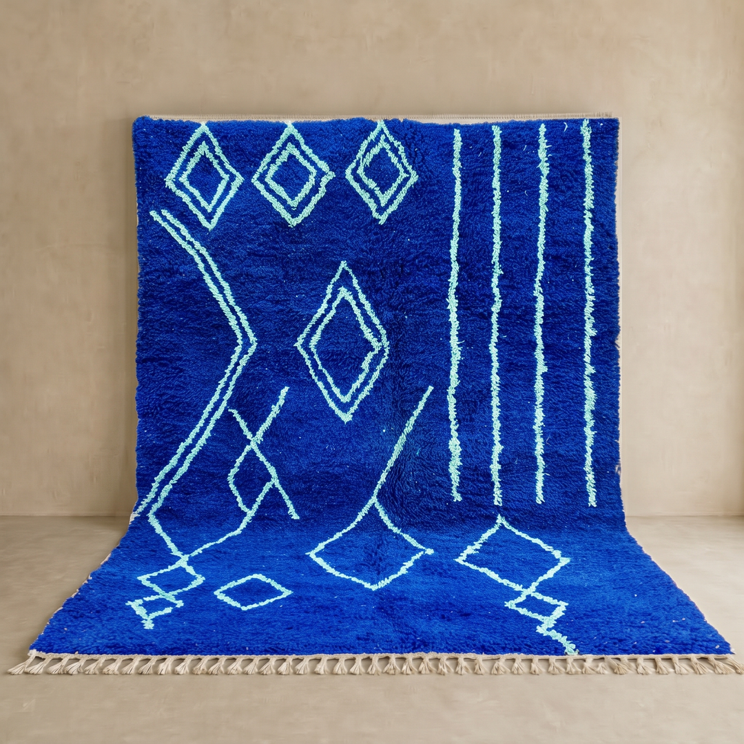 Handwoven royal-blue Moroccan wool rug with geometric light-blue diamond and line patterns
