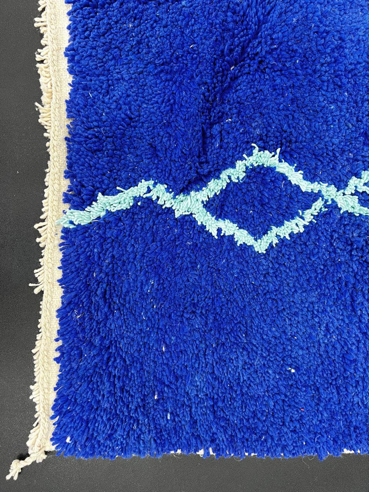 Handwoven royal-blue Moroccan wool rug with geometric light-blue diamond and line patterns