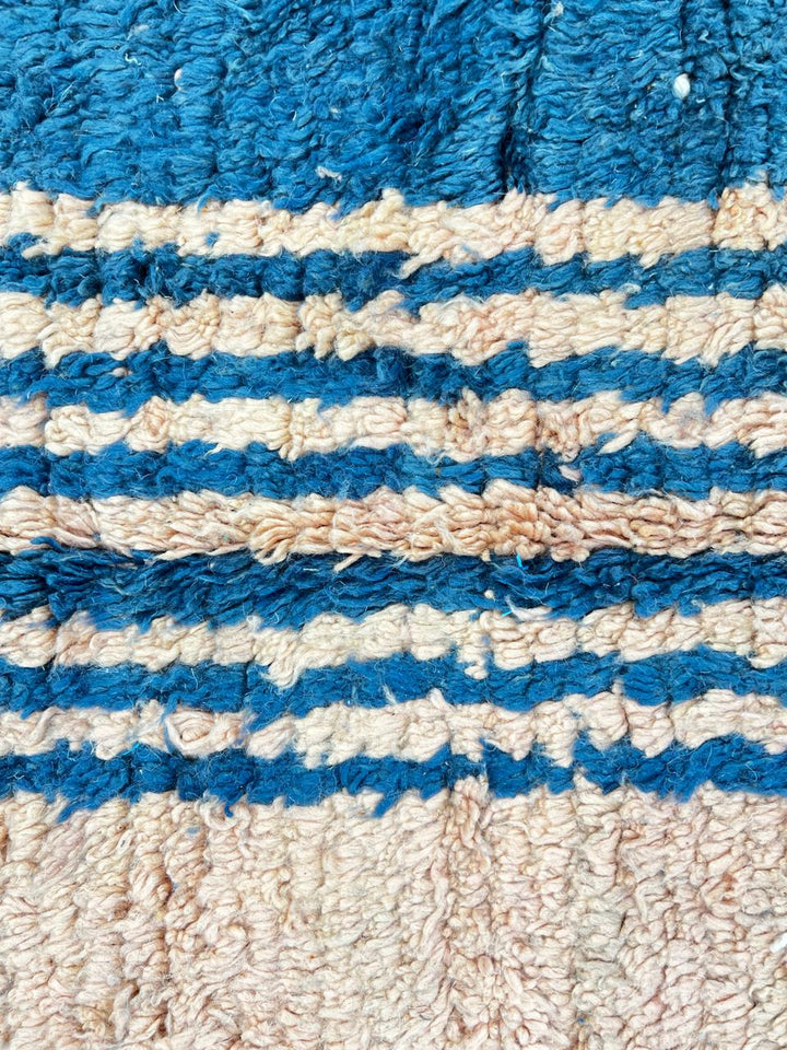 Terracotta Moroccan wool rug with blue and olive geometric shapes, handmade by Berber artisans