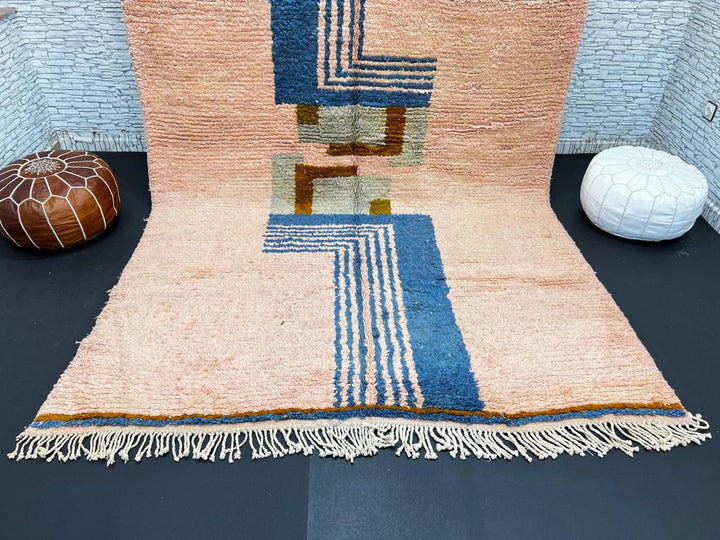 Terracotta Moroccan wool rug with blue and olive geometric shapes, handmade by Berber artisans