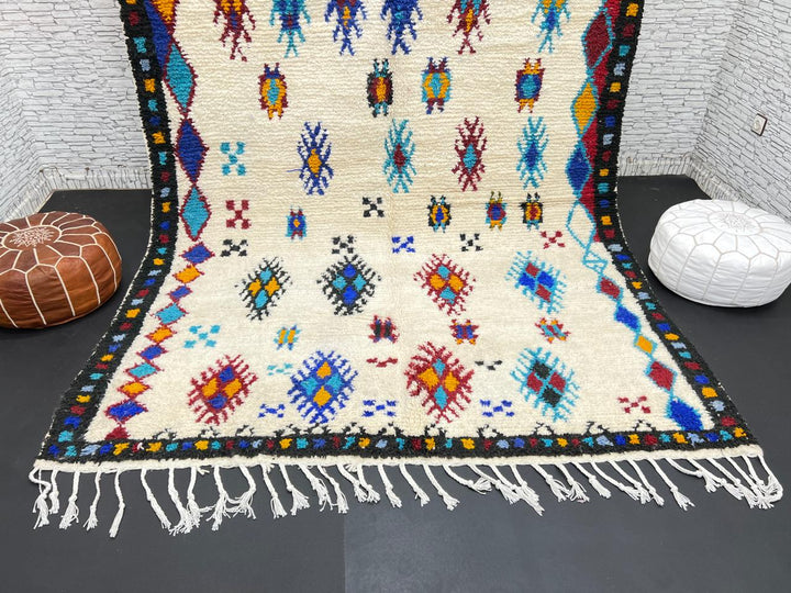 Handwoven Moroccan wool rug with colorful Berber tribal patterns and dark border
