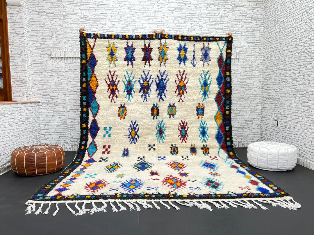Handwoven Moroccan wool rug with colorful Berber tribal patterns and dark border