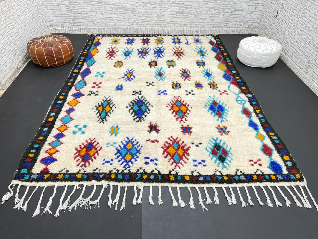 Handwoven Moroccan wool rug with colorful Berber tribal patterns and dark border