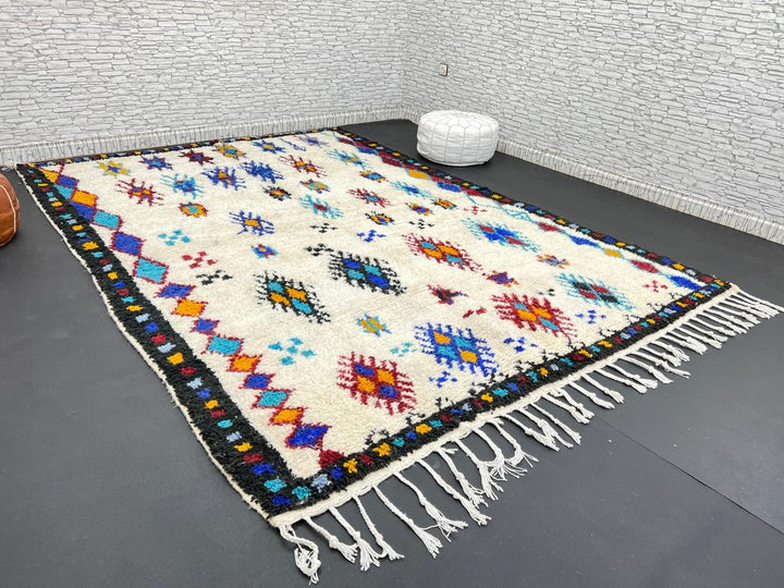 Handwoven Moroccan wool rug with colorful Berber tribal patterns and dark border