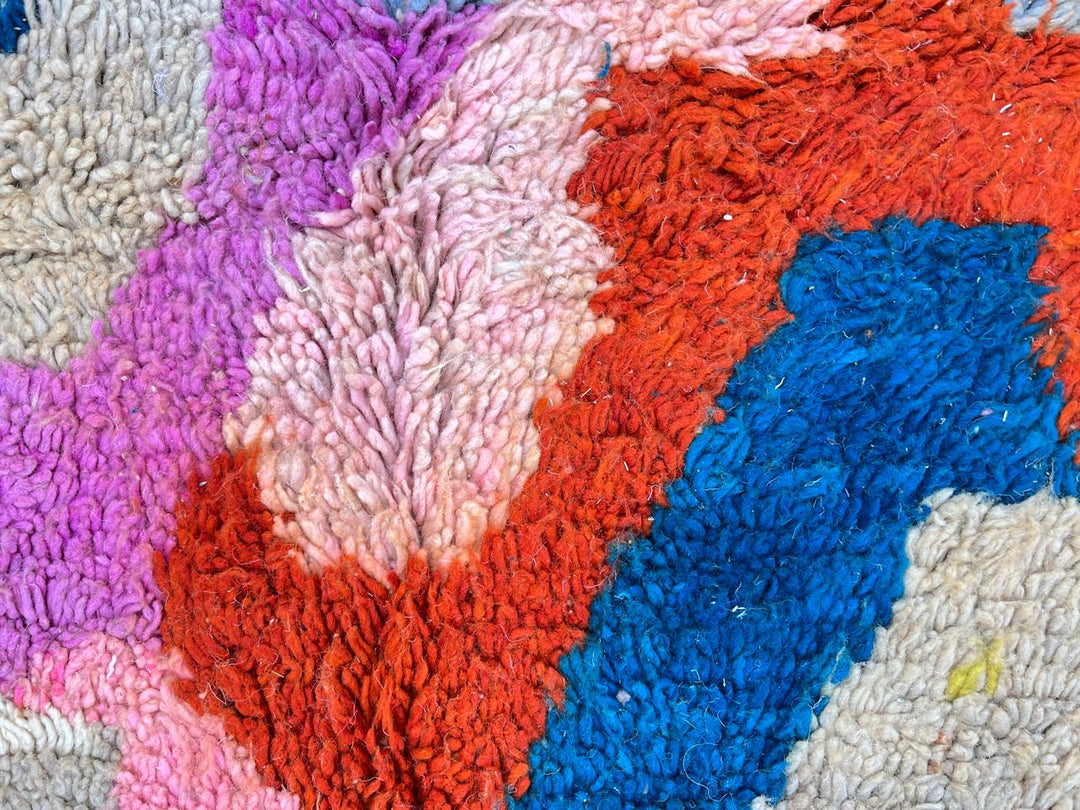 Handmade colorful Moroccan wool runner rug with abstract geometric pattern in red, blue, pink, and green tones