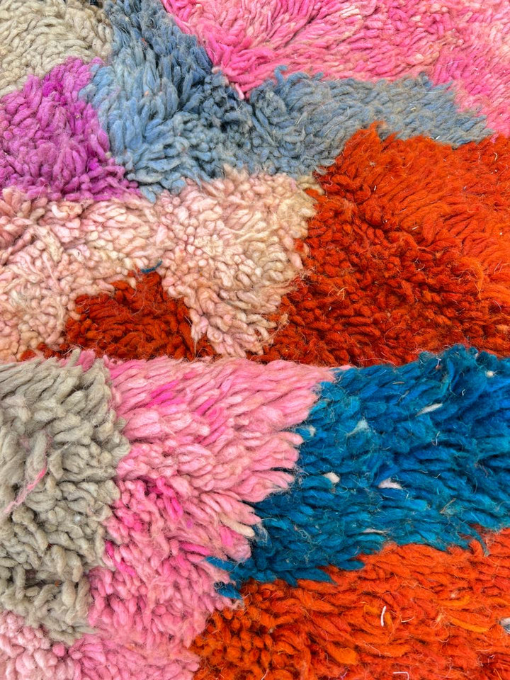 Handmade colorful Moroccan wool runner rug with abstract geometric pattern in red, blue, pink, and green tones