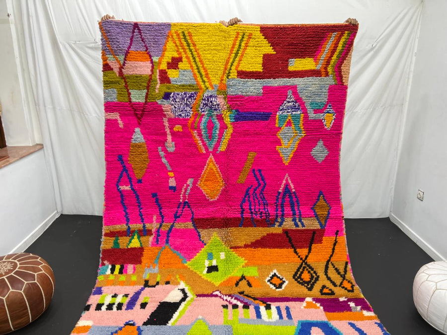 Collector Moroccan wool rug with vibrant abstract Berber patterns on a magenta pink background