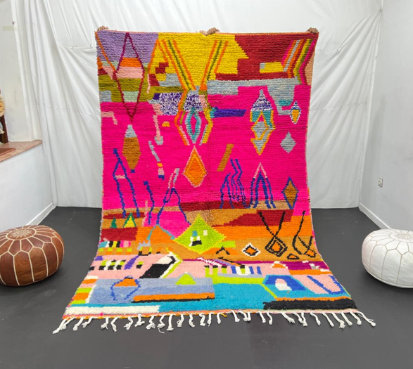 Collector Moroccan wool rug with vibrant abstract Berber patterns on a magenta pink background