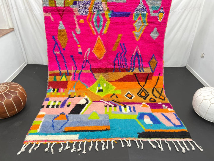 Collector Moroccan wool rug with vibrant abstract Berber patterns on a magenta pink background