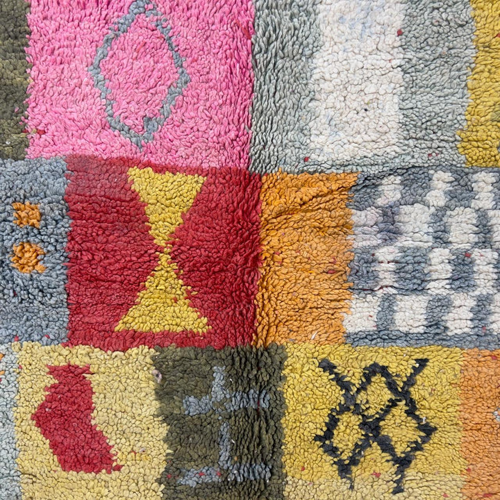 Handmade Moroccan Berber rug 95 with patchwork design in pink, mustard, and neutral tones, wool tribal carpet with geometric symbols