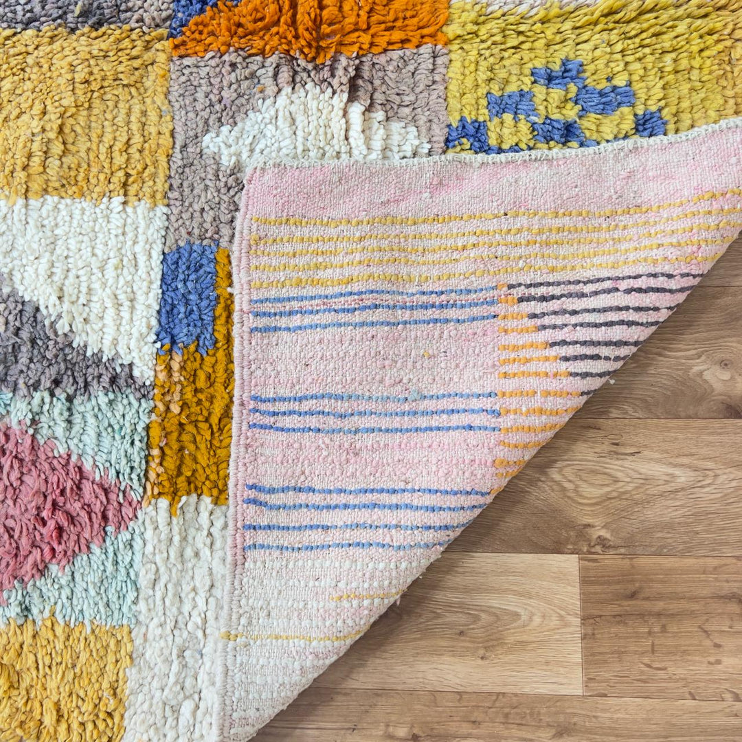 Vintage Moroccan wool rug with colorful geometric design in yellow, pink, blue, and ivory tones