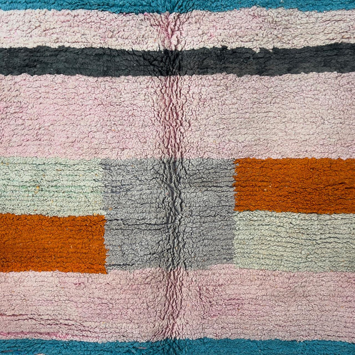 Vintage Moroccan wool rug 7.09 × 4.92 ft with striped design in blush pink, teal, charcoal, and burnt orange tones handmade Berber rug