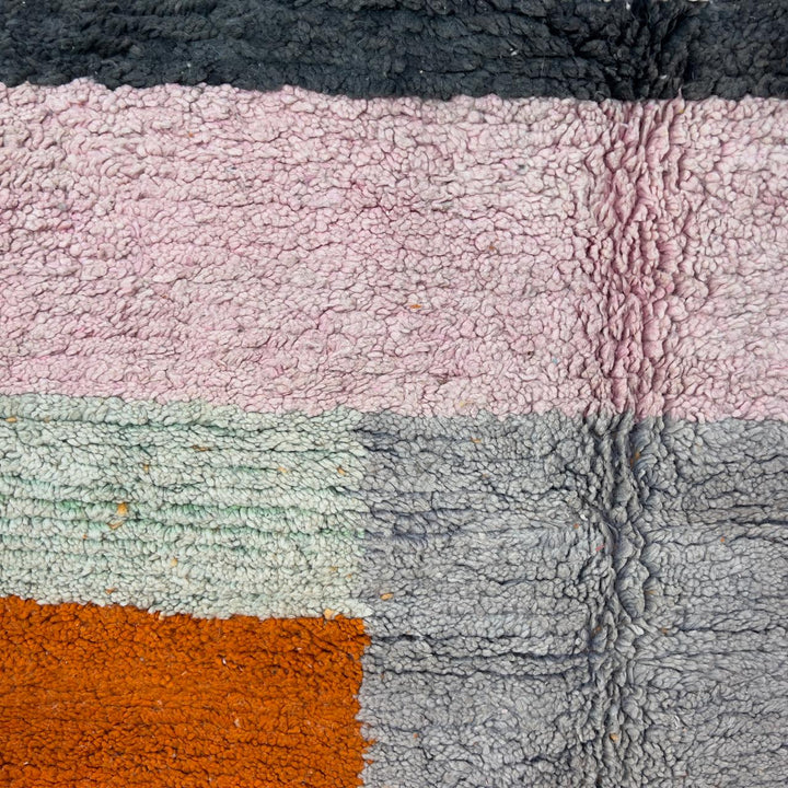 Vintage Moroccan wool rug 7.09 × 4.92 ft with striped design in blush pink, teal, charcoal, and burnt orange tones handmade Berber rug