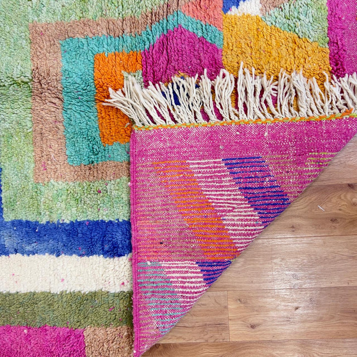 Vintage Moroccan wool rug with pink base and colorful geometric tribal patterns