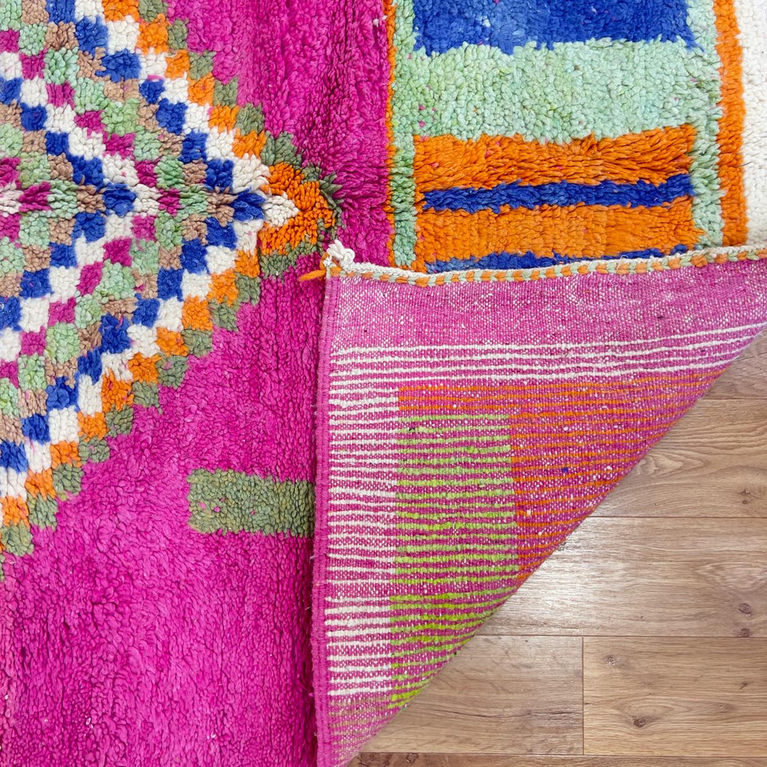 Vintage Moroccan wool rug with pink base and colorful geometric tribal patterns