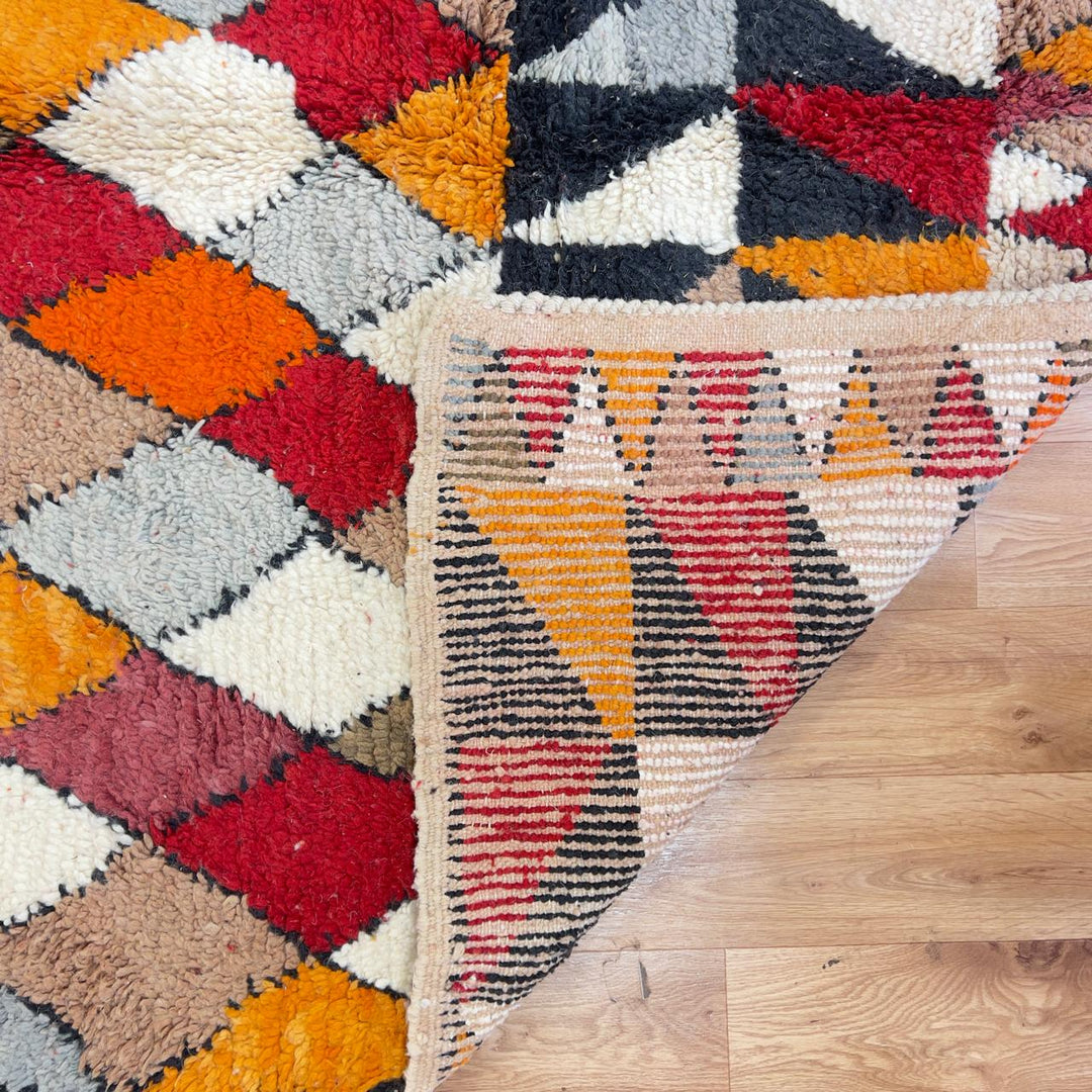 Vintage Moroccan wool rug with colorful geometric diamond and tribal patterns in red, orange and neutral tones, handmade Berber rug