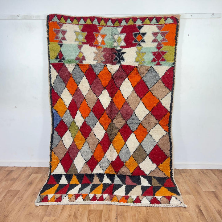 Vintage Moroccan wool rug with colorful geometric diamond and tribal patterns in red, orange and neutral tones, handmade Berber rug