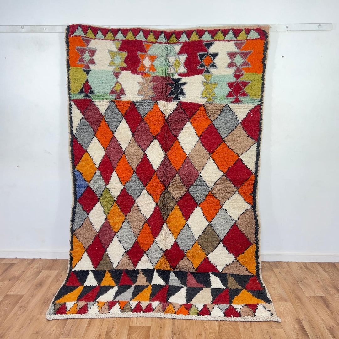 Vintage Moroccan wool rug with colorful geometric diamond and tribal patterns in red, orange and neutral tones, handmade Berber rug