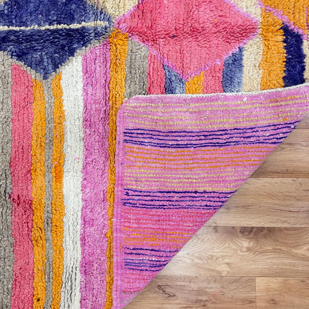 Vintage Moroccan wool rug with colorful geometric diamonds and striped pattern in pink, orange and purple tones, handmade Berber rug