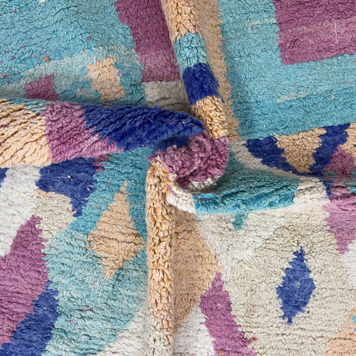 Vintage Moroccan wool rug 8.20 x 5.38 ft Rug 76 with abstract pastel design in pink, mint green, beige and blue tones, handmade Berber rug displayed on wooden floor
